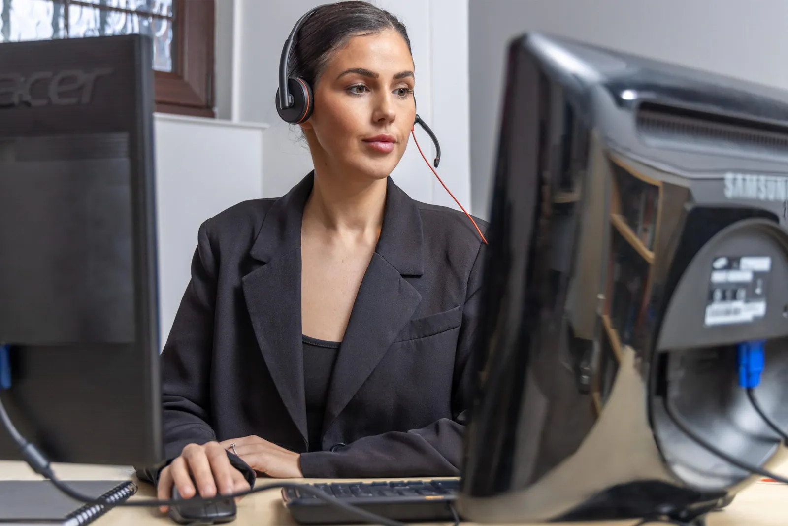 Receptionist with a headset taking a new business call for a marketing agency